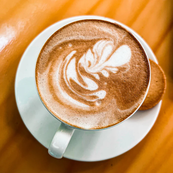 A cappuccino on a saucer on a wooden table