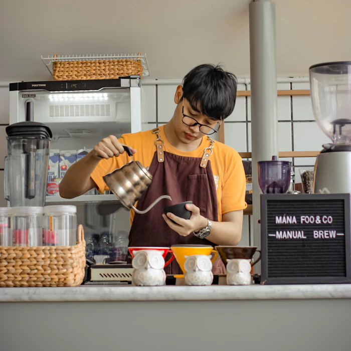 A barista steaming milk behind the counter