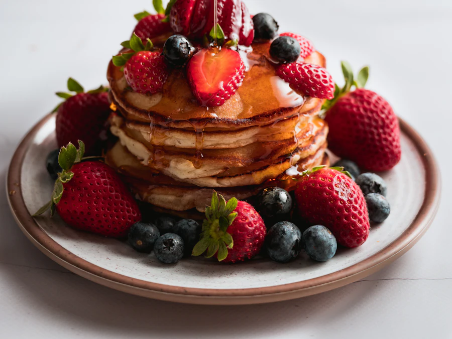A stack of hotcakes with strawberries and blueberries